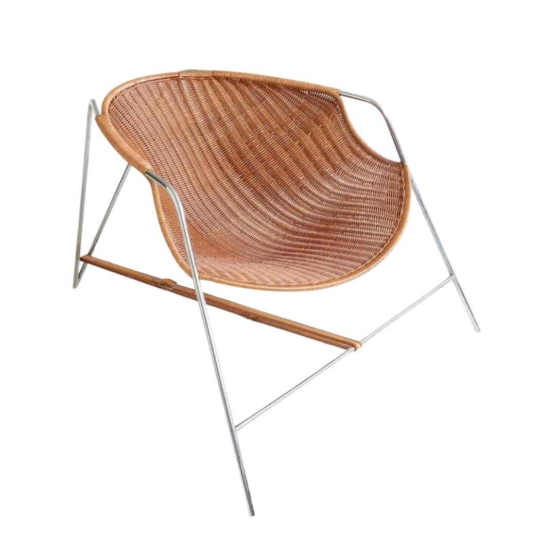 Coqueta fauteuil van Pete Sans voor BD Barcelona met roestvrijstalen buisframe, gevlochten rietzitting en leren verbindingsband tussen de poten.