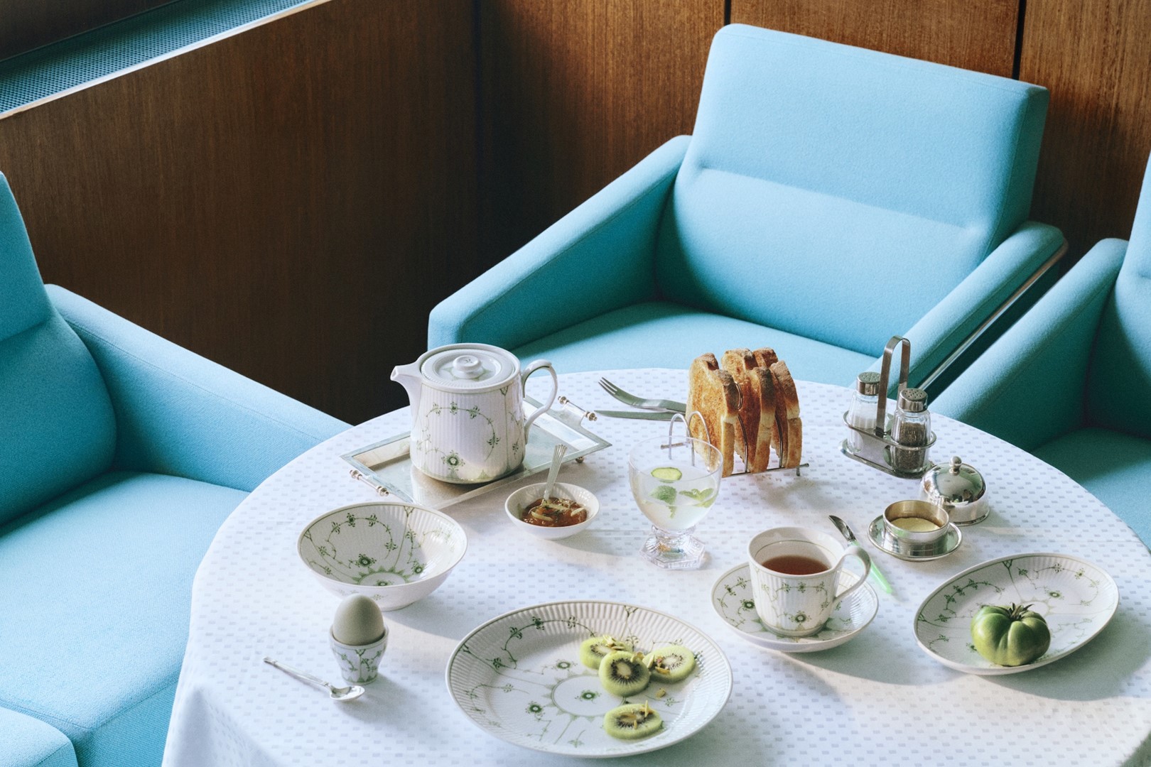 Groen porseleinen servies met theepot (75cl), ovale schaal (23,5cm), kom (35cl), bord (25cm), kop en schotel (24cl), eierdop en Aurora waterglas (27cl)