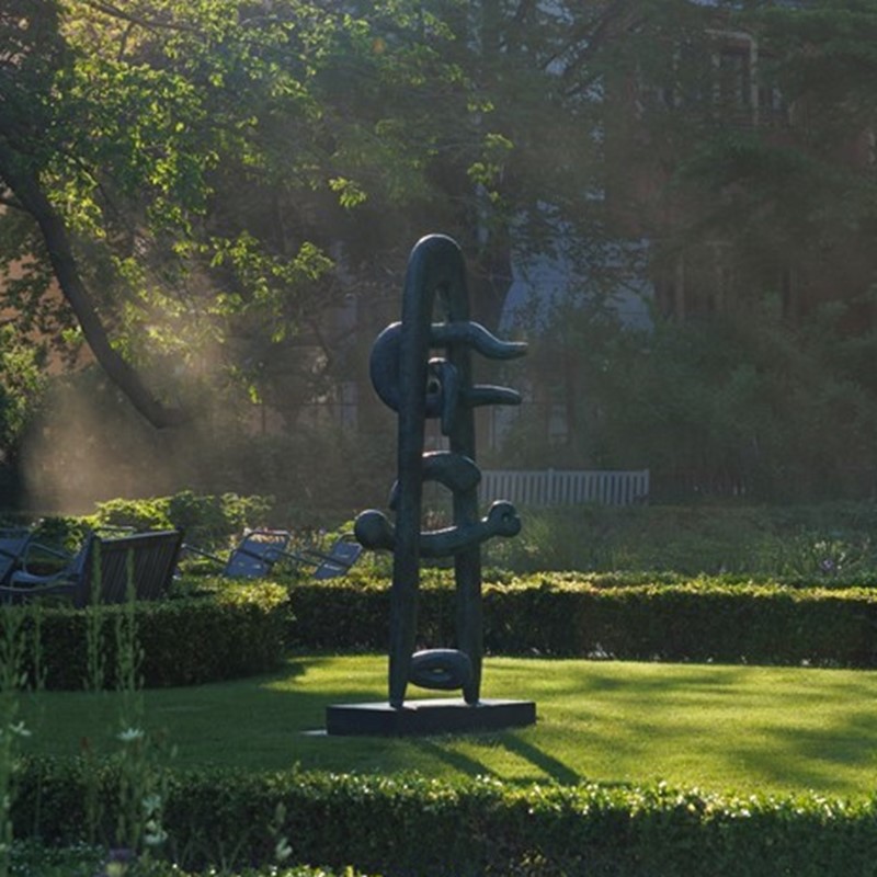 Sculptuur van Isamu Noguchi in de zonovergoten Rijksmuseumtuinen in Amsterdam. Onderdeel van de zomertentoonstelling 2025 met ongeveer vijfentwintig abstracte beelden in steen en brons.
