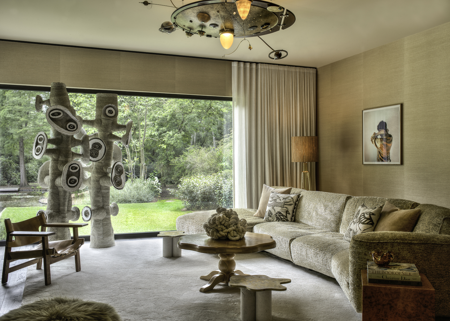 Het indrukwekkende kunstwerk voor het raam is een ontwerp van Frits Achten, verkrijgbaar bij Burna Collectables. De messing sidetables zijn een ontwerp van Burna Collectables x studio speciaal. 