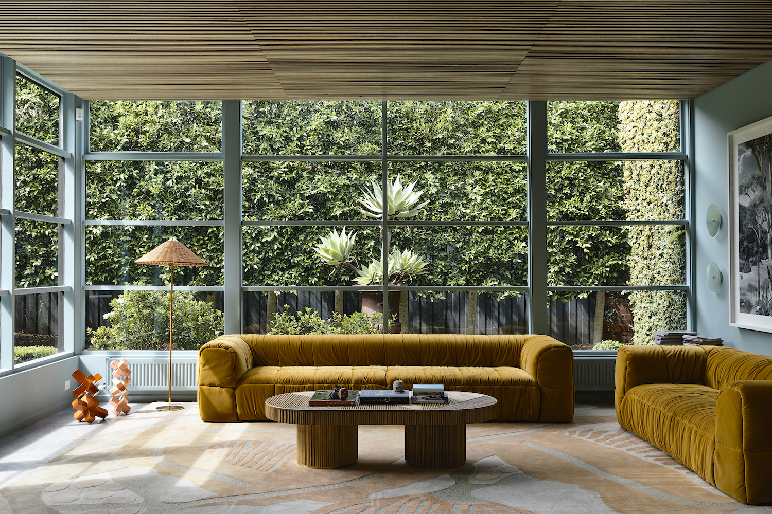 De woonkamer is afgestemd op het overvloedige groen buiten. Met rotanstoel van Feelgood Designs en okergele Strips Sofa’s van Cini Boeri voor Arflex.