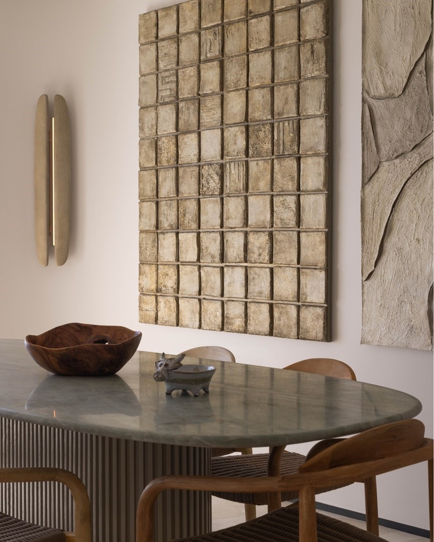Wandwerk van Margo van Erkelens met getextureerde tegelvakken in crèmetinten, boven een eettafel