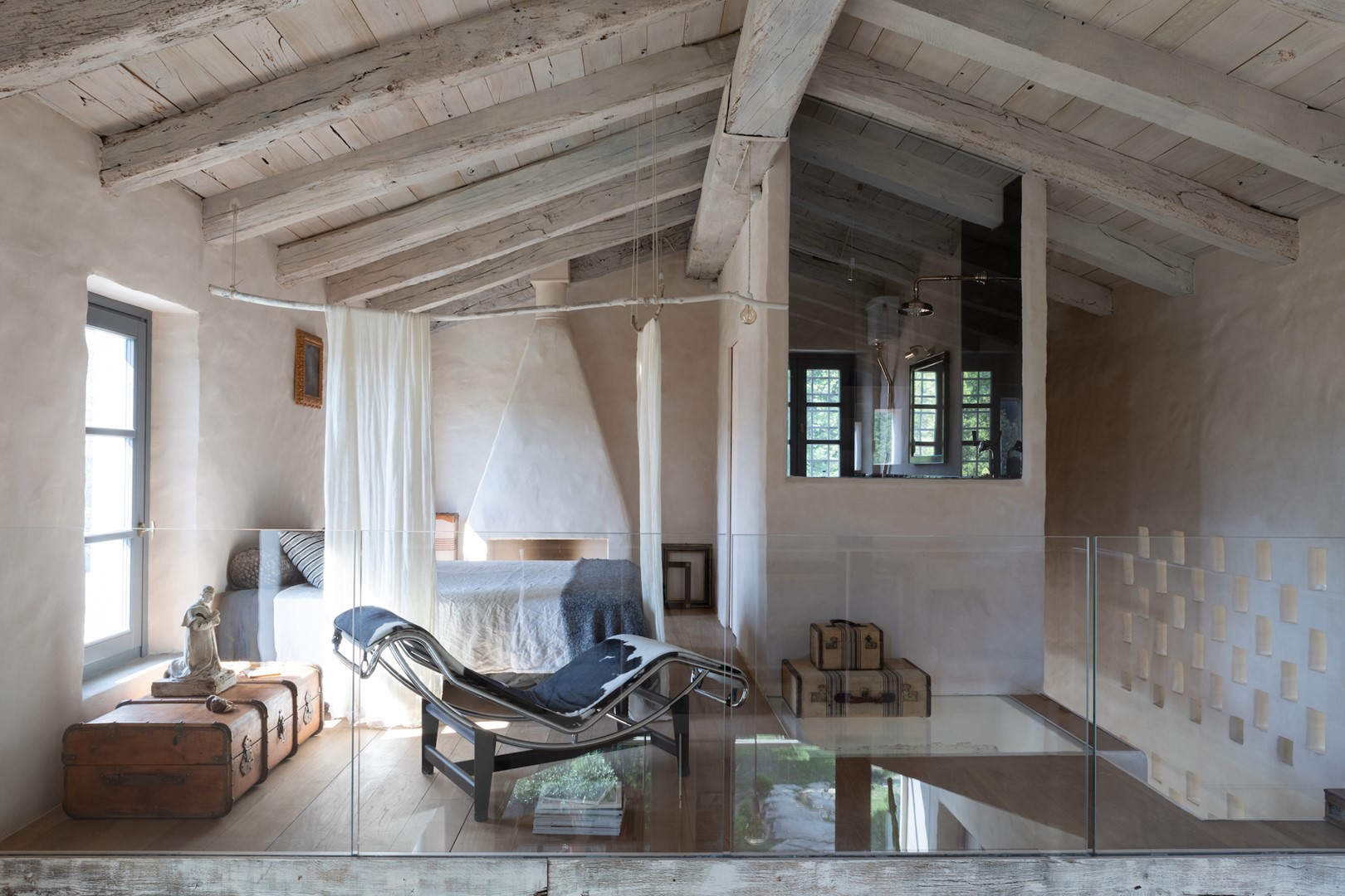 In de hoofdslaapkamer op de mezzanine, met doorkijkje naar de badkamer, domineert de LC4 fauteuil van Le Corbusier voor Cassina. De haard is ontworpen door architect Augusta Pasqualetti.