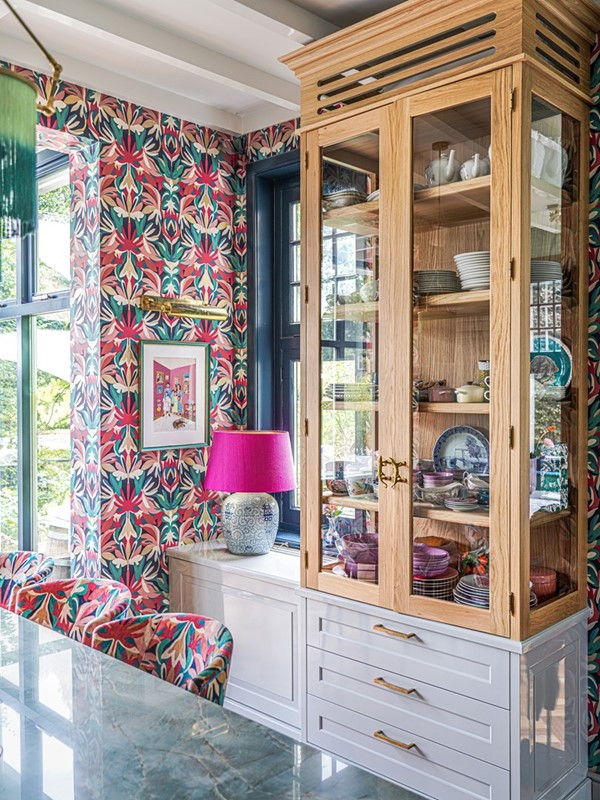 Deel van de keuken, ontworpen door Eef en uitgevoerd door Rijksen, met een keukenblad van groene onyx via De Keukenbladenfabriek. Het bovenste gedeelte van de kast is van eiken en bevat greepjes van messing gekko’s, meegenomen uit Costa Rica. Barkrukken en behang van Harlequin. Familieportret door Saskia Mendez. Fotografie: RmariusB.