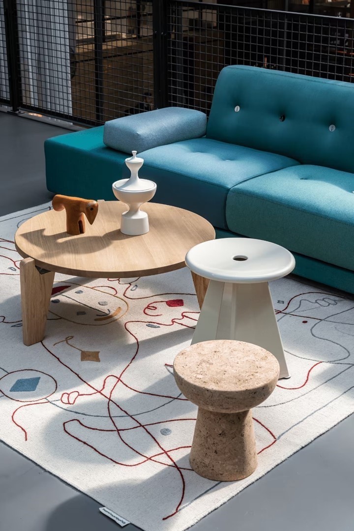 Moderne interieurwinkel in Den Bosch met designbank, bijzettafels en grafisch vloerkleed.