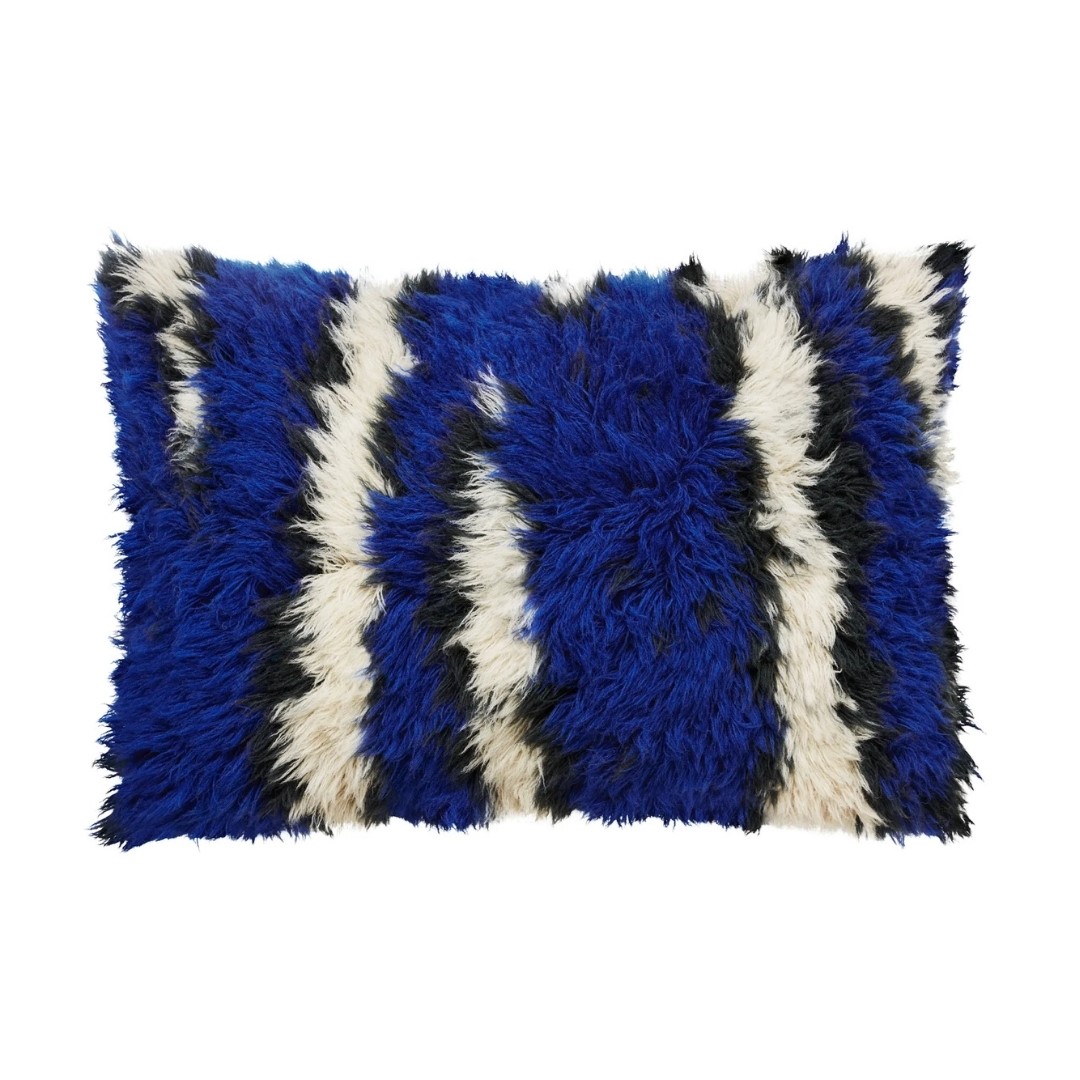 Groot, langharig kussen met speelse strepen in kobaltblauw, zwart en gebroken wit.