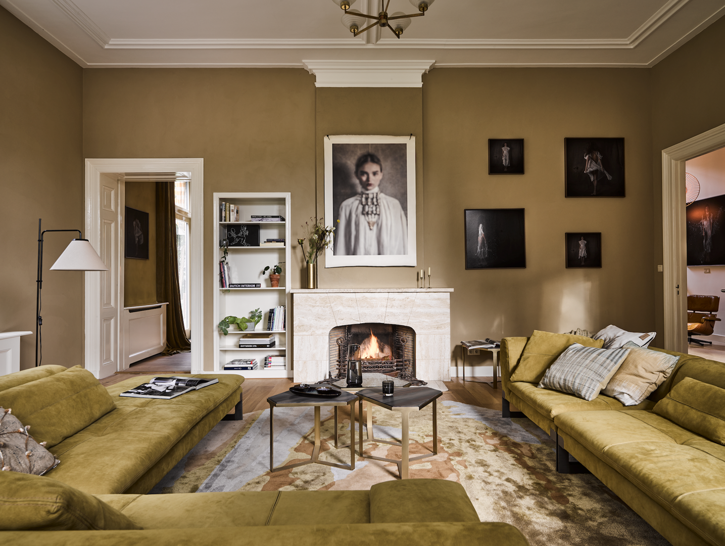 De living met een loungebank van Baxter, bijzettafels via Co van der Horst en lamp van Marset. Het tapijt is een eigen ontwerp voor Frankly Amsterdam. Boven de schouw kunst van Rachel Dubbe, het vierluik is eigen werk.