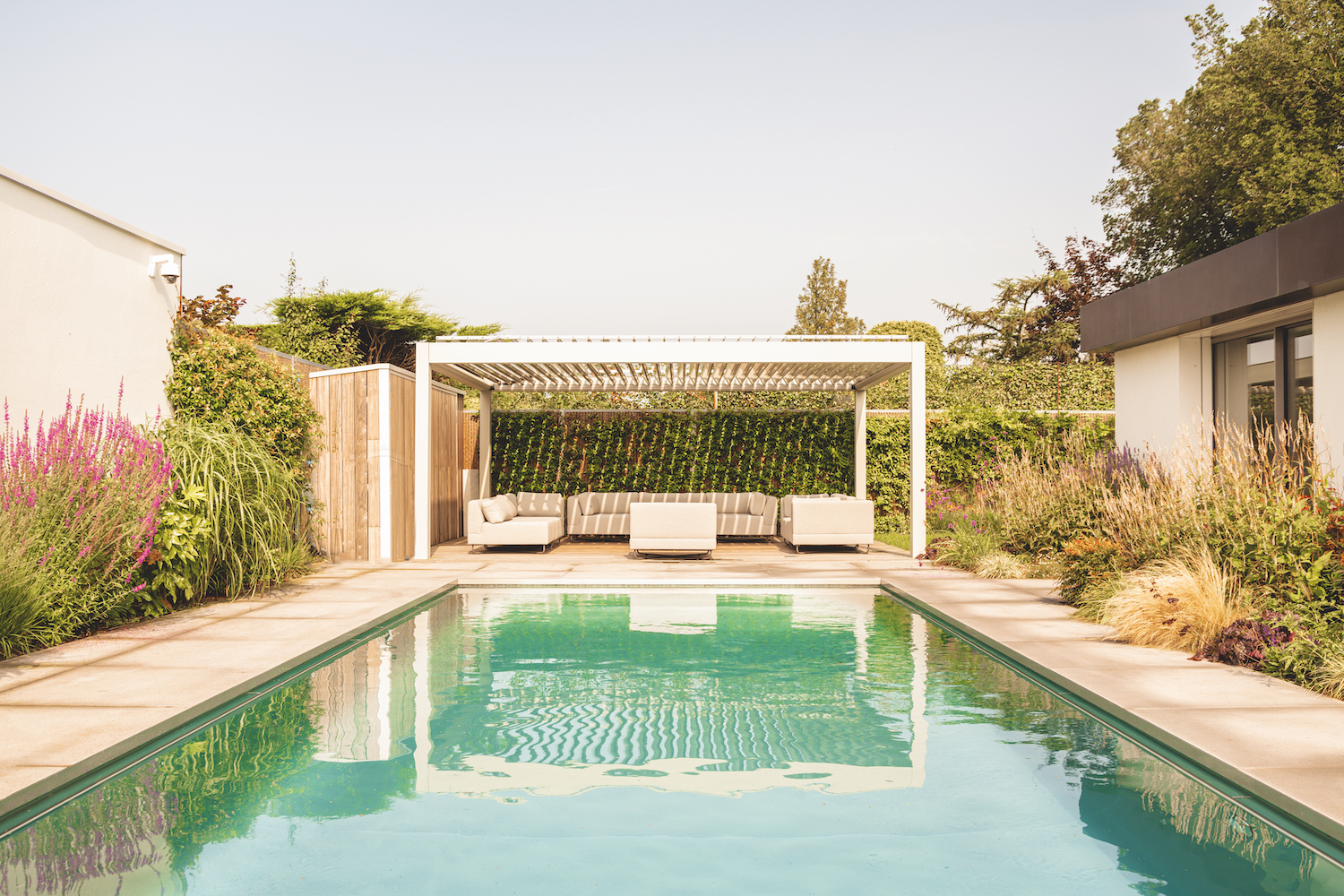 In de ruime en zonnige tuin bevinden zich een zwembad met bubbelplateau, een lounge- en een eethoek.
