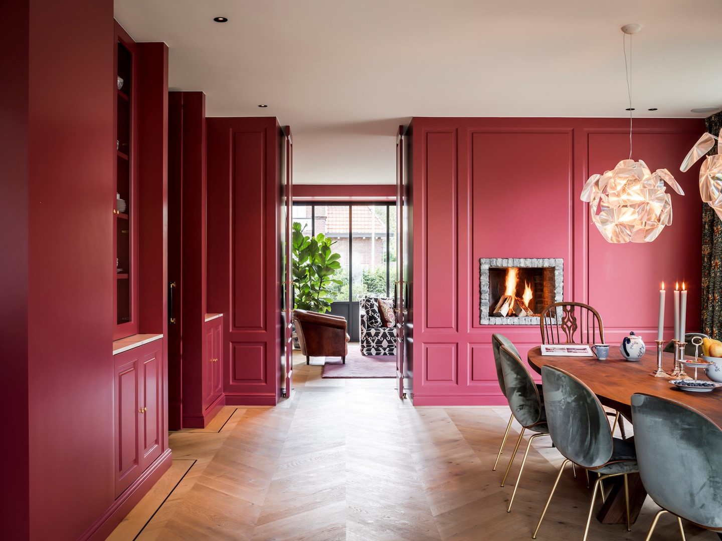 De maatwerkpanelen geschilderd in Eating Room Red No. 43 van Farrow & Ball geven een modern Indian Summer gevoel. Rond de open haard (op tafelhoogte) zijn nostalgische waaltjes aangebracht, waarmee een subtiele spanningsboog is gecreëerd tussen oud en nieuw.