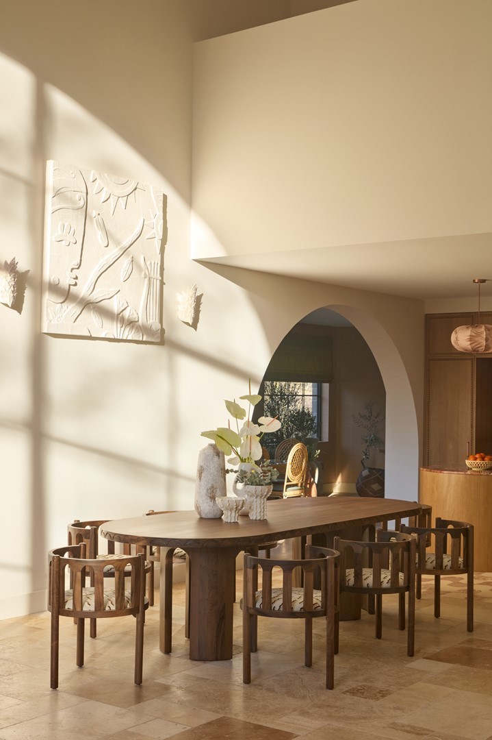 Mediterraan interieur met hoge boogramen, natuurlijke tinten, op maat ontworpen meubels en uitzicht op zwembad en wijngaarden in de Provence.