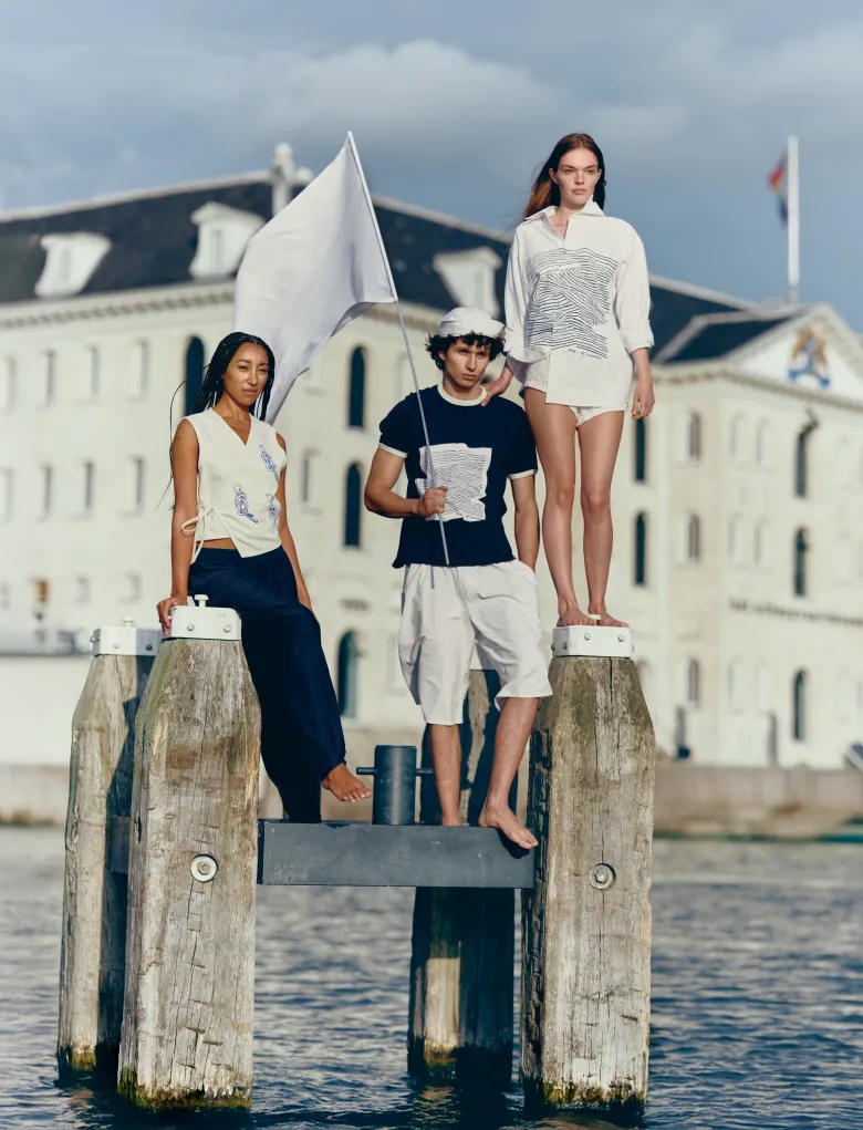 Modellen in maritiem geïnspireerde modecollectie Oceanista poseren op houten palen in het water voor Het Scheepvaartmuseum in Amsterdam, onderdeel van de tentoonstelling Oceanista – Fashion & Sea. Fotografie: Boris Lutters