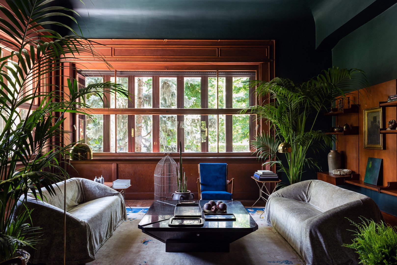 De woonkamer met originele ramen, Model 516 fauteuils van Gio Ponti voor Cassina en Mantilla 225 banken van Kazuhide Takahama voor Simon International. Op het Chinese art deco vloerkleed van Nichols uit 1920 staat een marmeren tafel die Daminelli zelf ontwierp.