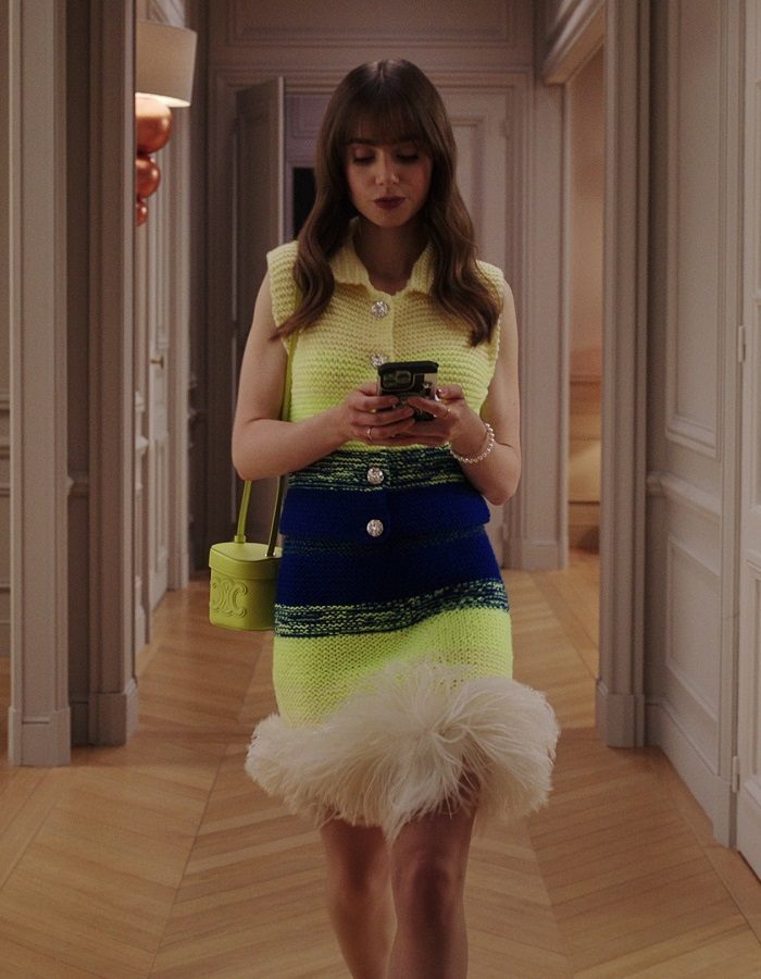 Emily in de gang van haar Parijse kantoor in Emily in Paris seizoen 3, aflevering 2, met de Silk Magnet Bracelet van Yana Nesper om haar pols. Fotografie: Netflix.