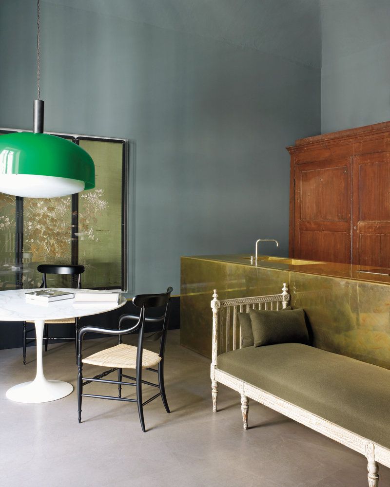 Interieur met naadloze gietvloer, groene hanglamp, marmeren eettafel en messing keukenblad, gefotografeerd door Henry Bourne.