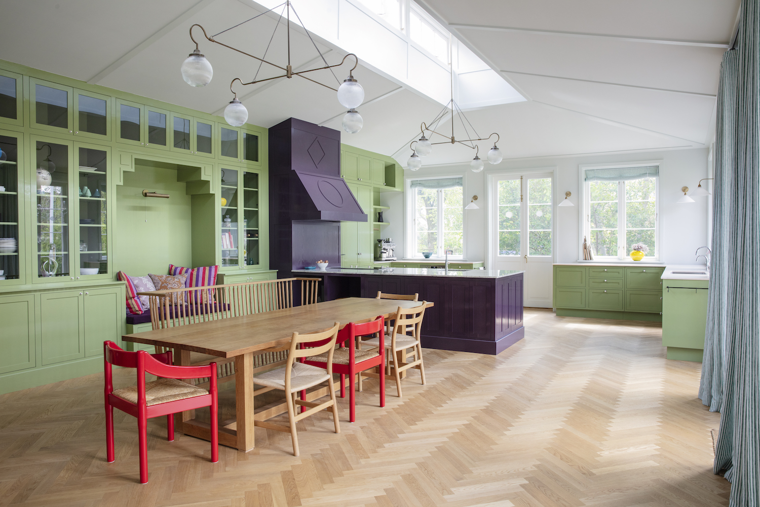 Het Chromatic Stripe-behang en de verftint op de kasten genaamd Brassica, beide Farrow & Ball, creëren een circusachtige sfeer.