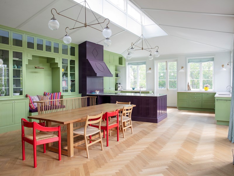 Het Chromatic Stripe-behang en de verftint op de kasten genaamd Brassica, beide Farrow & Ball, creëren een circusachtige sfeer.