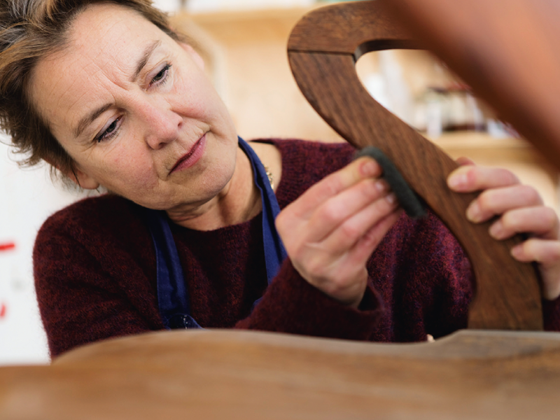 Aanbrengen van harde was op een eikenhouten draaifauteuil uit eind negentiende eeuw.