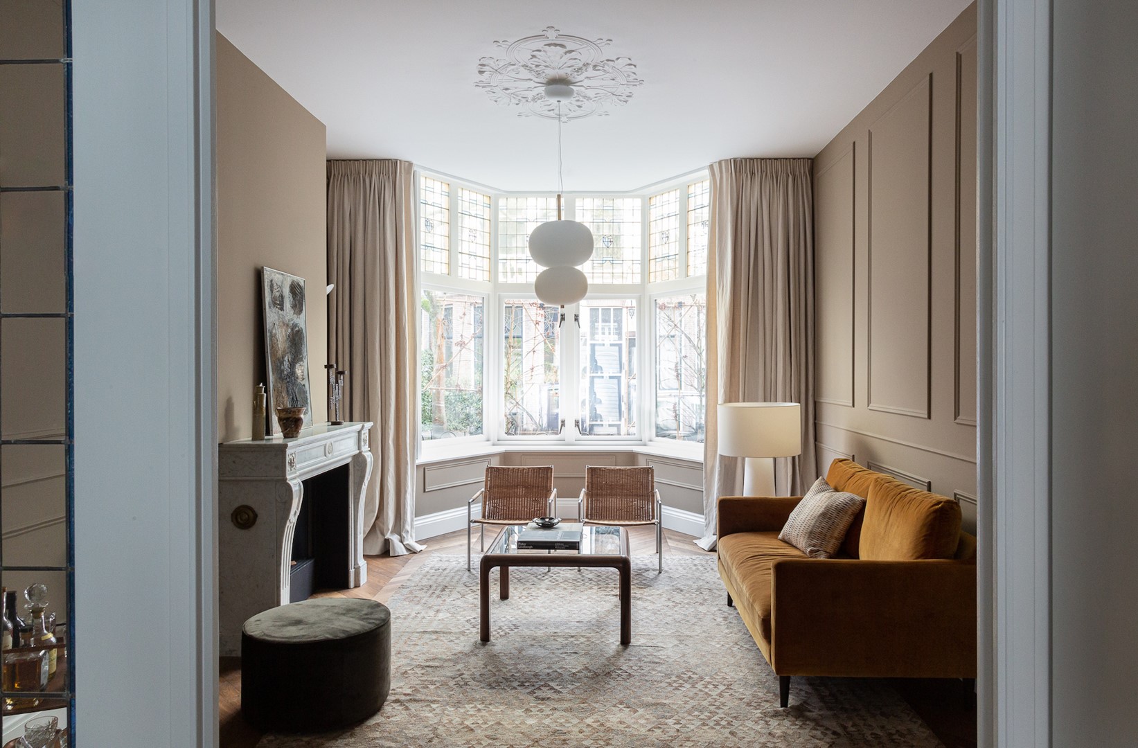 De Ilargi double 36- hanglamp is van Grok Lighting. De Big Shadow-vloerlamp van Marcel Wanders staat bij vintage SZ 01- stoelen van Martin Visser. De gordijnen zijn gemaakt van Madison-stof van Designs of the Time.