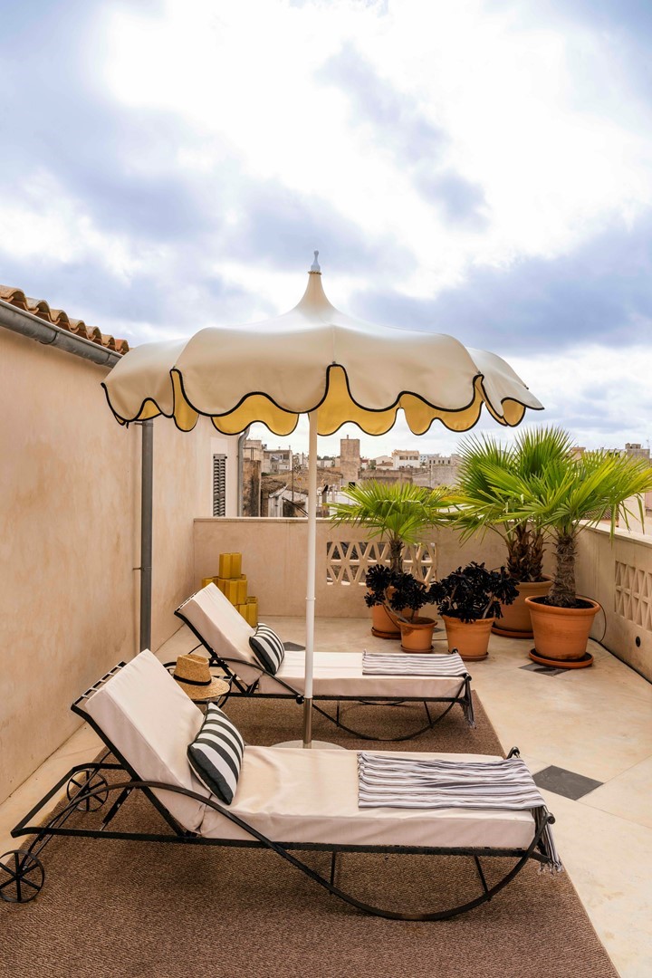 Terras inrichten met ligstoelen, gestreepte kussens en een parasol in mediterrane stijl