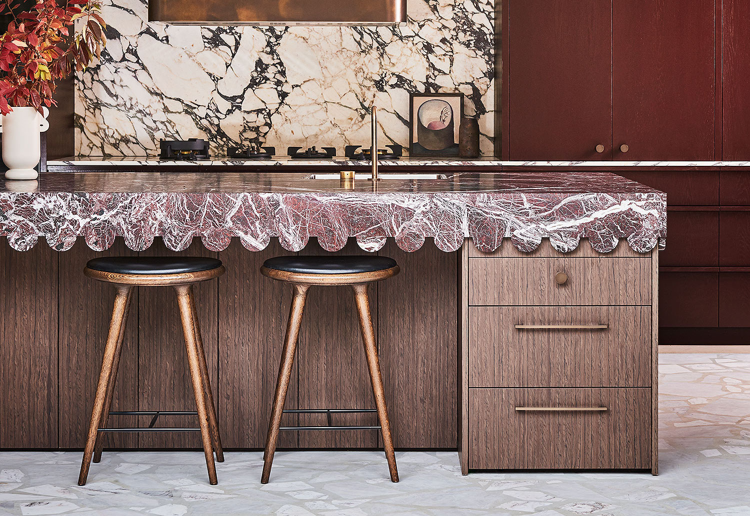 Het werkblad met golvend effect, verwijzend naar de bogen in het huis, is van Rosso Levantomarmer.