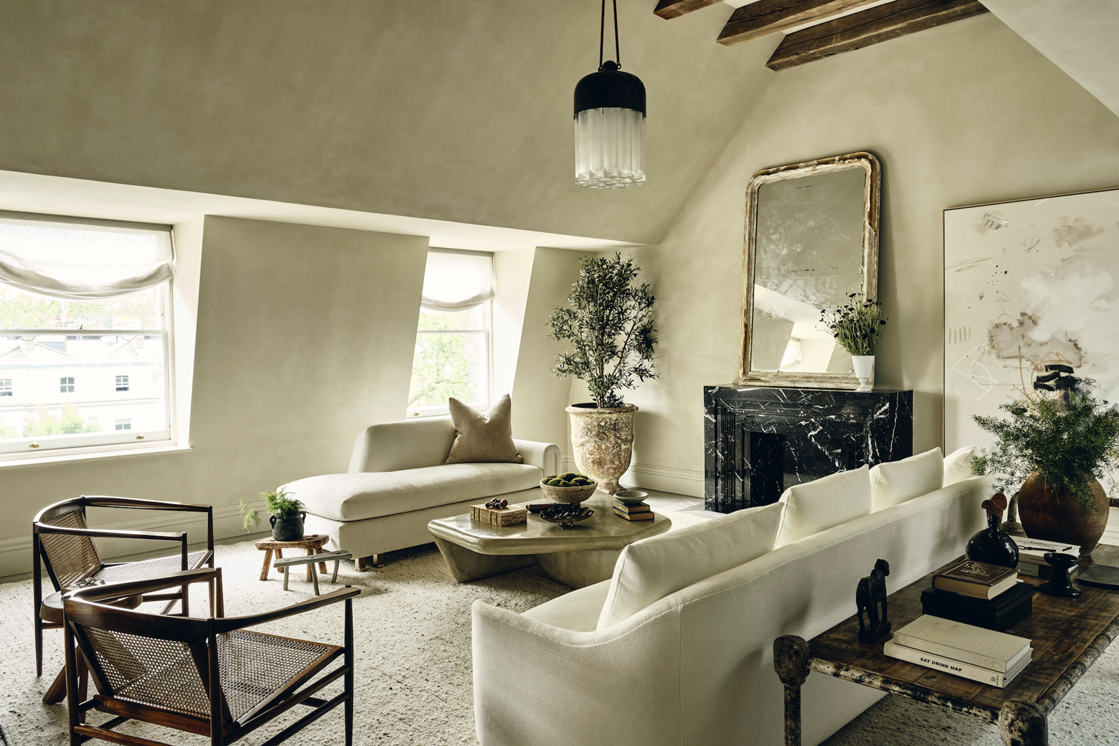 In de woonkamer is gekozen voor natuurlijke tinten en rotanmeubels. De stoelen zijn vintage. 