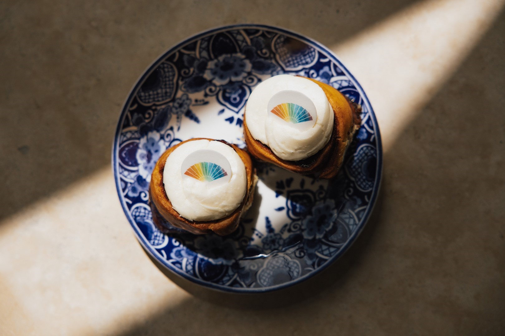 Delftsblauw bordje met vakjes met een regenboogvlaggetje van marsepein.